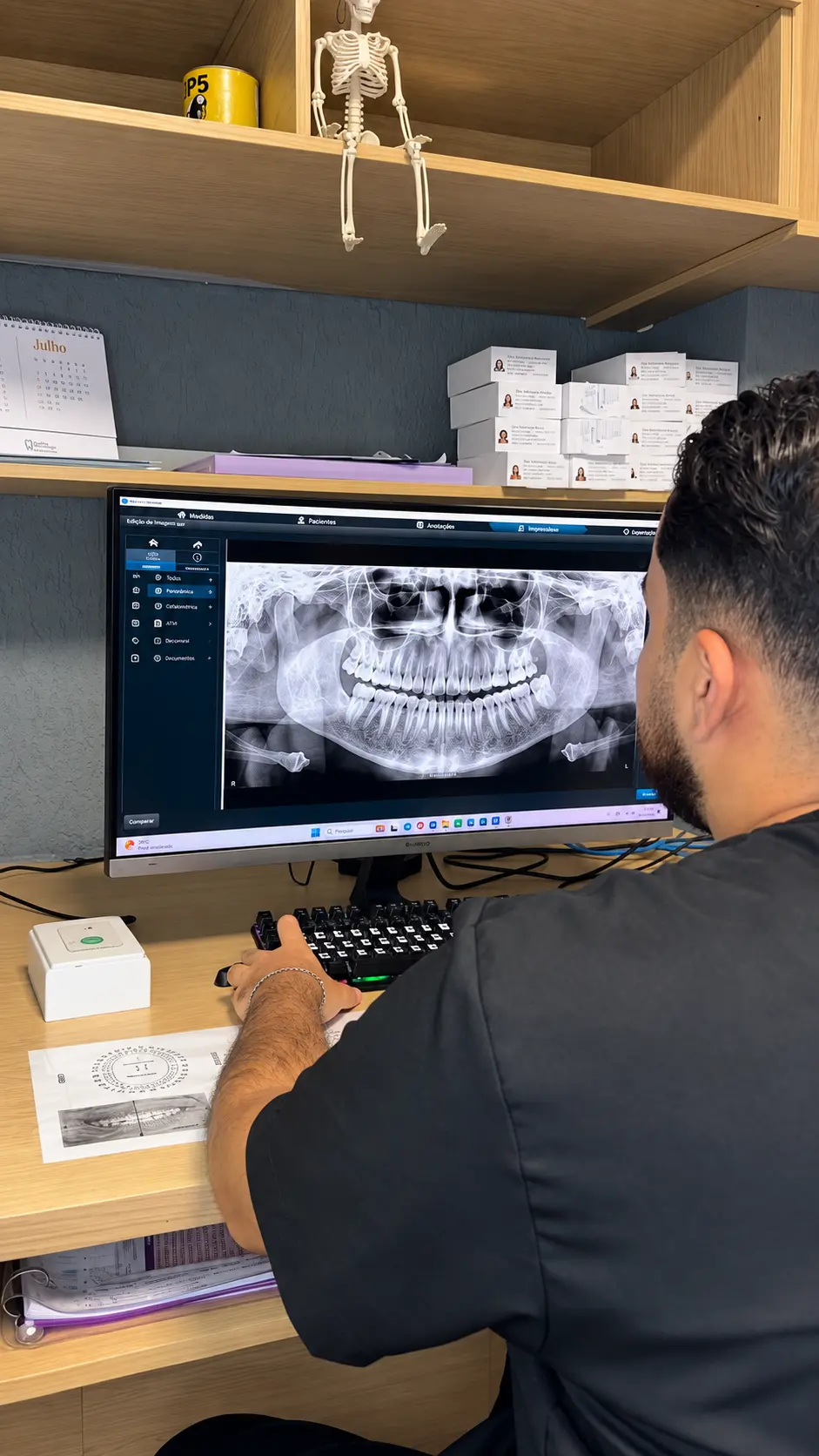 Profissional da CIOB analisando uma radiografia panorâmica no computador