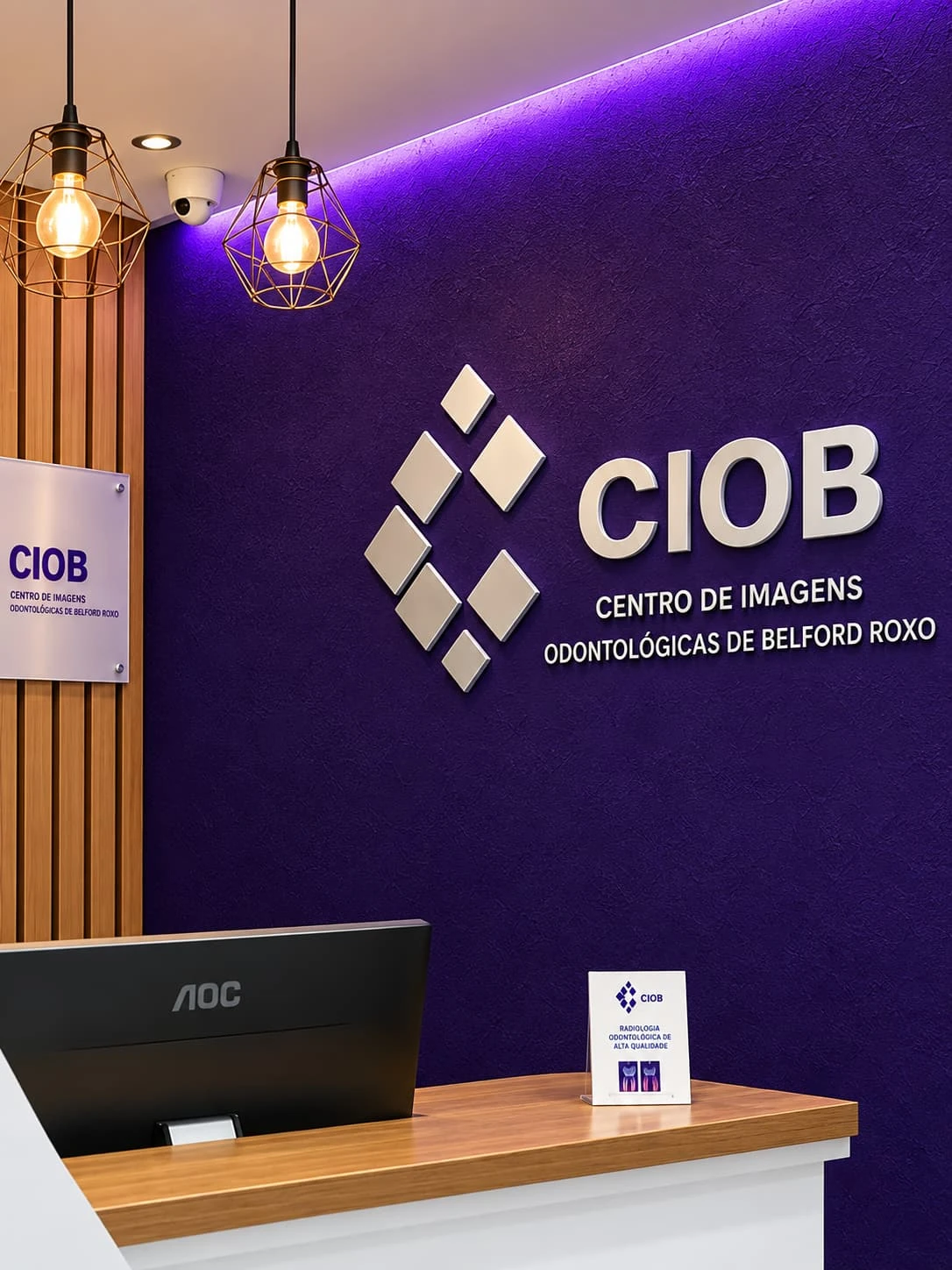 Recepção da CIOB com o logotipo e o nome Centro de Imagens Odontológicas de Belford Roxo na parede roxa